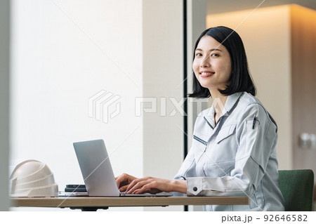 パソコンで仕事をする作業服の女性 92646582