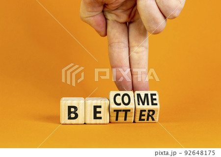 Become better symbol. Businessman turns wooden cubes and changes the concept word Better to Become. Beautiful orange table orange background. Business become better concept. Copy space. 92648175