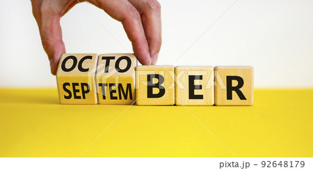 Symbol for the change from September to october. Businessman turns wooden cubes and changes the word 'September' to 'October'. Beautiful white background, copy space. Happy October concept. Symbol for the change from September to october. Businessman turns wooden cubes and changes the word 'September' to 'October'. Beautiful white background, copy space. Happy October concept. 92648179