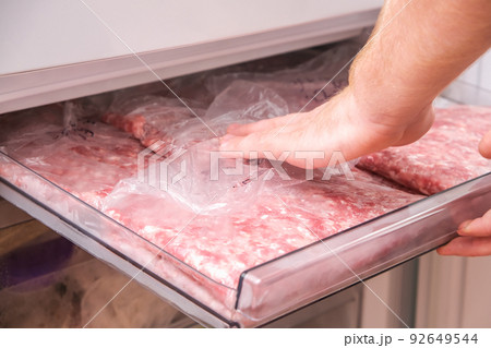 man puts minced pork and beef in the freezer in man puts minced pork and beef in the freezer in 92649544