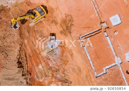 To lay down the underground storm sewer pipes, the excavator digs a pit in order to connect to the sewer system 92650854