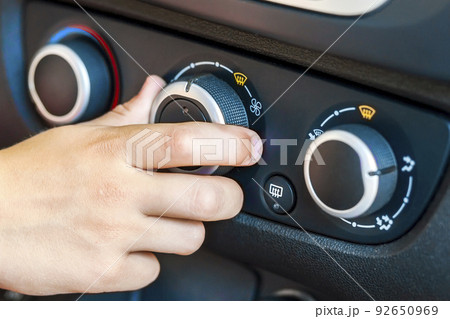 Closeup of a human hand rotating car temperature control, shallow depth of field shot Closeup of a human hand rotating car temperature control, shallow depth of field shot 92650969
