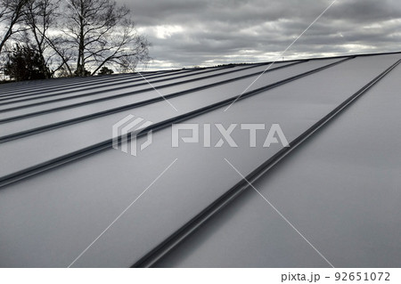 Close-up detail of house roof made from gray metal sheets. 92651072