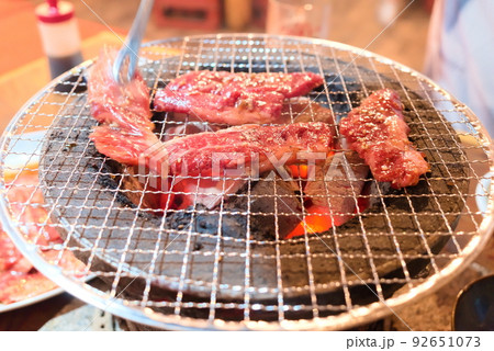 七輪で肉を焼いているシーン 92651073