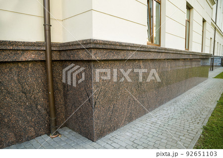 Close up view of part of a building facade with the surface of granite wall. Natural stone materials. Close up view of part of a building facade with the surface of granite wall. Natural stone materials. 92651103