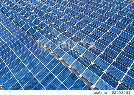 Aerial view of blue photovoltaic solar panels mounted on industrial building roof for producing green ecological electricity. Production of sustainable energy concept. 92652581
