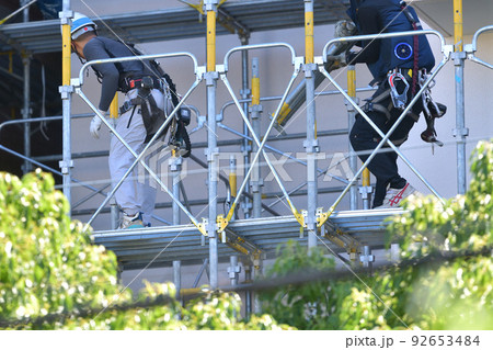 大規模修繕　とび職人　マンションの外壁塗装用仮設足場撤去作業風景 92653484
