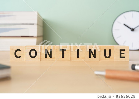 「CONTINUE」と書かれたブロックが置かれたデスク 92656629