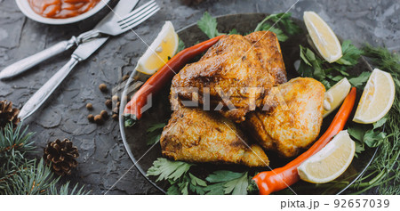 Roasted turkey or chicken. The Christmas table is served with a turkey decorated with bright tinsel. Fried chicken. table setting. Christmas dinner. Photo banner. top view on wooden background 92657039