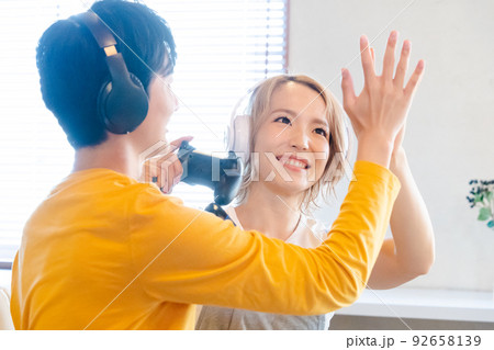 テレビゲームで遊ぶ若い男女 92658139