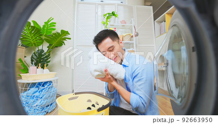 asian man doing laundry asian man doing laundry 92663950