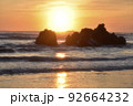 冬の海の日の出と岩礁 92664232