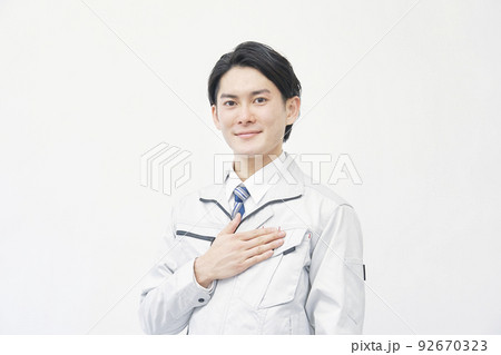胸に手をあてる笑顔の作業員のポートレート 白バック 胸に手をあてる笑顔の作業員のポートレート 白バック 92670323