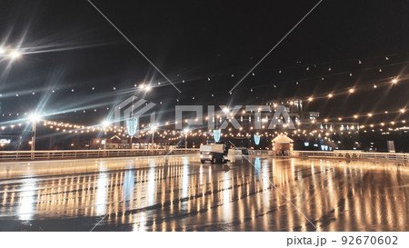 Night clear ice skating rink with cleaning machine Night clear ice skating rink with cleaning machine 92670602