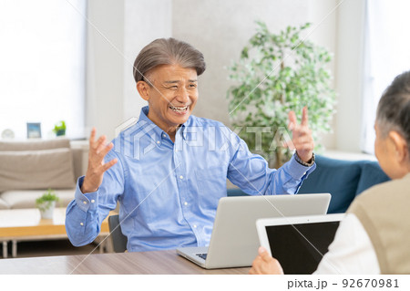 自宅のリビングでビジネスの話をするシニア男性2人 92670981