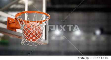 Basketball ball scoring the winning  points on basketball net hoop on basketball arena. 92671640