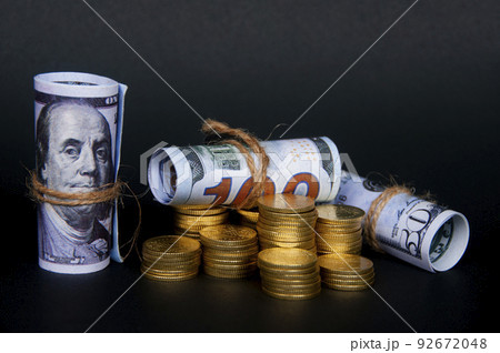 Gold coins and bank notes isolated on dark background. Copy space and business concept 92672048