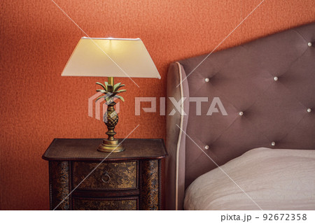 Bright eco light in the corner of a modern bedroom. New led technology meets traditional interior design. Lamp is creating cozy atmosphere in room. Wooden, glass table, blue curtains Bright eco light in the corner of a modern bedroom. New led technology meets traditional interior design. Lamp is creating cozy atmosphere in room. Wooden, glass table, blue curtains 92672358