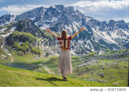 Woman tourist in Mountain lake landscape on Durmitor mountain in Montenegro beautiful Durmitor National park with lake glacier and reflecting mountain Portrait of a disgruntled girl sitting at a cafe Woman tourist in Mountain lake landscape on Durmitor mountain in Montenegro beautiful Durmitor National park with lake glacier and reflecting mountain Portrait of a disgruntled girl sitting at a cafe 92672809