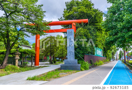 日本の川崎都市景観　緑に包まれた川崎の稲毛神社（右の歩道には青色の自転車優先レーンが設けられた） 92673185
