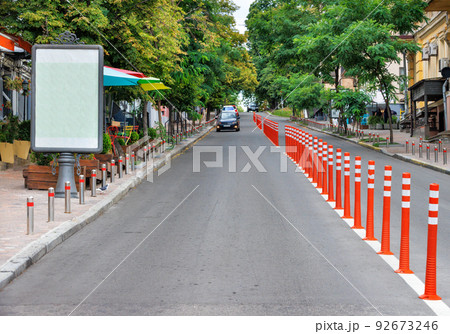 The carriageway of the road on a city street stretching into the distance. Urban summer landscape. Copy space. 92673246