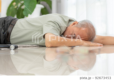Senior Asian man falling down from chair unconsciousness alone at home. Accident in elderly man down on the floor lose consciousness or hearth attack. Elderly symptom and sudden pain. Elder care 92673453