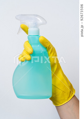 Cleaning concept - hand in yellow cleaning gloves holds spray bottle 92673506