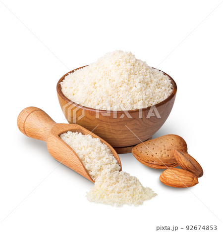 Wooden bowl and scoop full of almond flour isolated on white 92674853