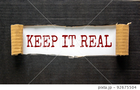 The words 'keep it real' appearing behind torn black paper. Beautiful background. Business concept. 92675504