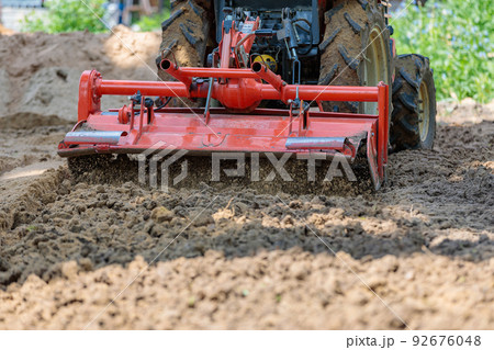 Cultivator for a mini-tractor for loosening the soil. Agricultural work. Excavation. Close-up Cultivator for a mini-tractor for loosening the soil. Agricultural work. Excavation. Close-up 92676048
