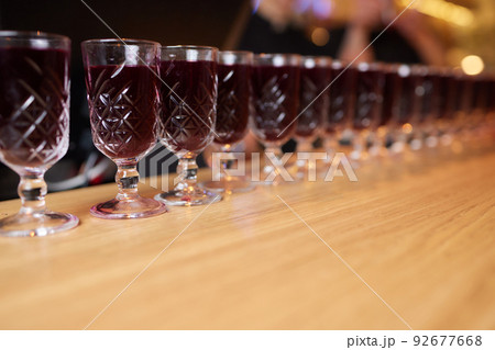 cocktails shots are on a tray on the bar counter. red cocktail shots on the bar. cocktails shots are on a tray on the bar counter. red cocktail shots on the bar. 92677668