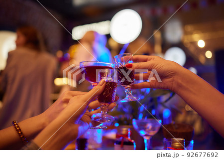 people at the bar try tinctures, red tinctures in glasses, alcoholic shots. 92677692