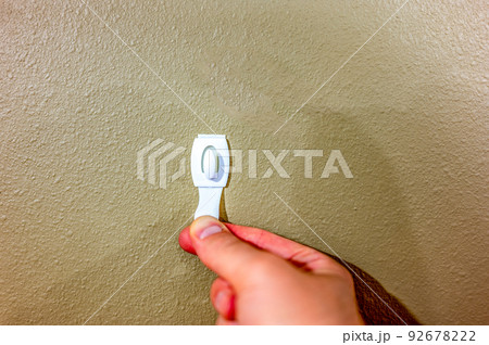Selective focus on adhesive strip wall hanger that can be removed by pulling tape 92678222