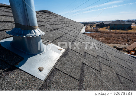 Flashing and weather sealing on vent chimney on a shingle roof Flashing and weather sealing on vent chimney on a shingle roof 92678233