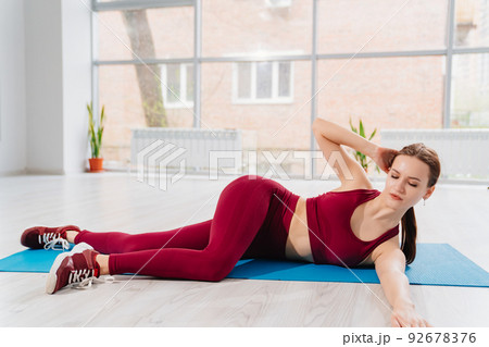 a beautiful and athletic girl in a burgundy tracksuit does exercises a beautiful and athletic girl in a burgundy tracksuit does exercises 92678376