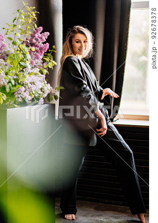 a sexy blonde topless woman in a jacket in a dark room by the window. a sexy blonde topless woman in a jacket in a dark room by the window. 92678378