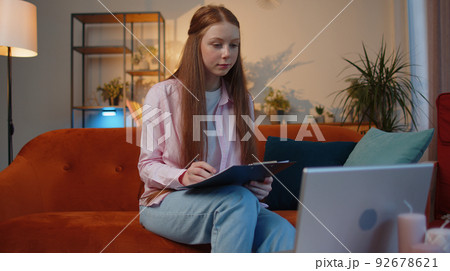 Child girl accounting payments calculating monthly expenses bank bills, analysing paperwork at home Child girl accounting payments calculating monthly expenses bank bills, analysing paperwork at home 92678621