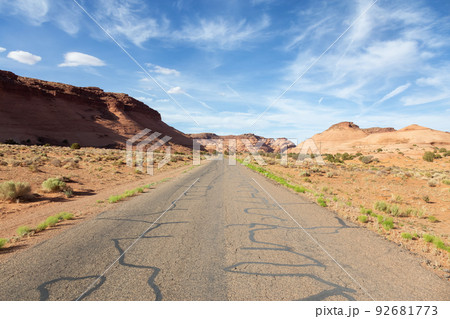 Scenic Road in the Dry Desert with Red Rocky Mountains in Background. 92681773
