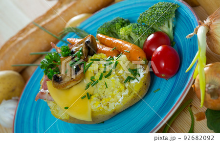 Baked potato with bacon, vegetables, mushrooms Baked potato with bacon, vegetables, mushrooms 92682092