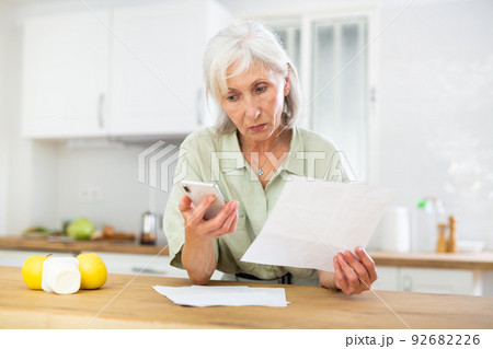 Senior woman analyzing bills at home 92682226