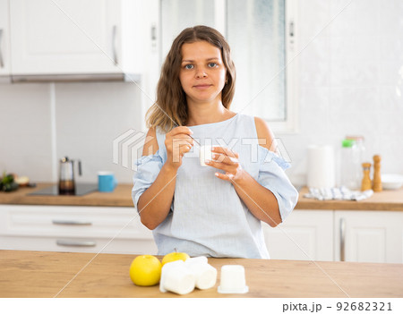 Housewife enjoying delicious yogurt and apples for breakfast Housewife enjoying delicious yogurt and apples for breakfast 92682321