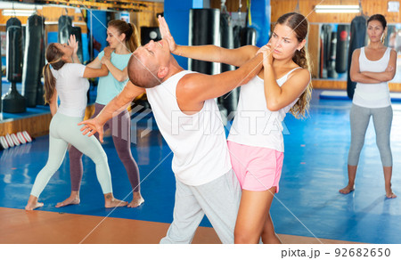 Young woman practicing palm strike with man in self defense training 92682650
