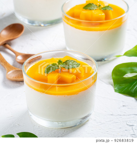 Delicious double colored mango panna cotta mousse pudding on white table background. 92683819