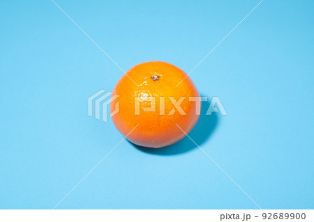 Bright orange tangerine close-up on a blue background 92689900