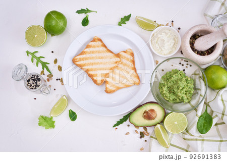 Toasts preparation - grilled toast bread and mashed avocado 92691383
