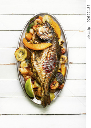 Baked fish with pineapple, mango and kiwi. Baked fish with pineapple, mango and kiwi. 92692185