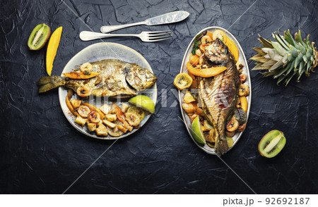 Baked fish with pineapple, mango and kiwi. 92692187