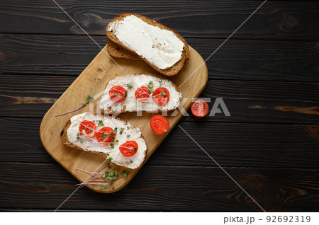 Toasts with microgreens on the table. Healthy food, vegan food and dieting concept. Toasts with microgreens on the table. Healthy food, vegan food and dieting concept. 92692319