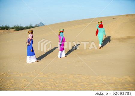 Art photo: the girls are walking in Nam Cuong sand dunes. 92693782