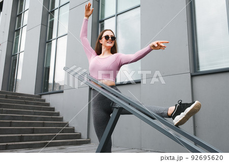 Fitness girl is stretched on the stairs. 92695620